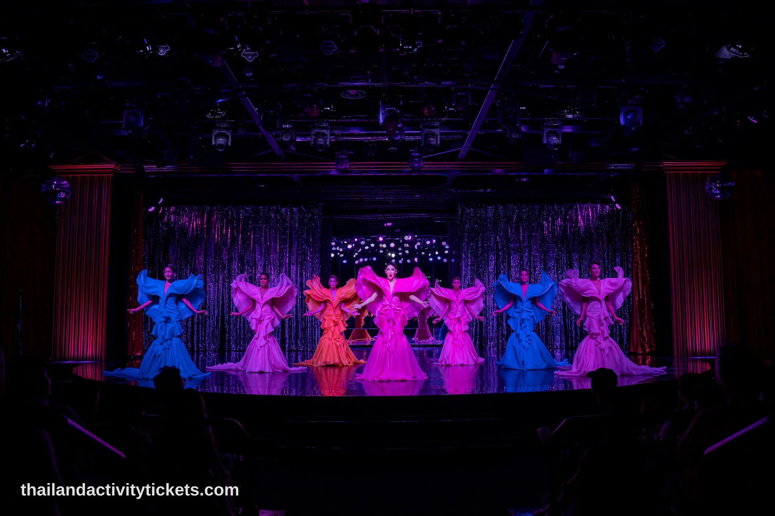 Tourists taking photos with Calypso Cabaret performers in Bangkok