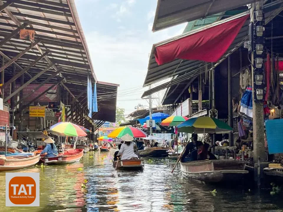 Vendors folding stall awnings at Maeklong Umbrella Market before train passes