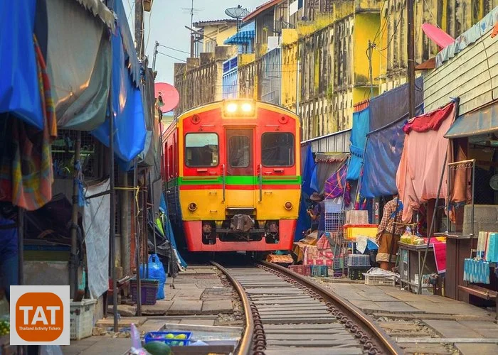 Train passing through Maeklong Railway Market stalls