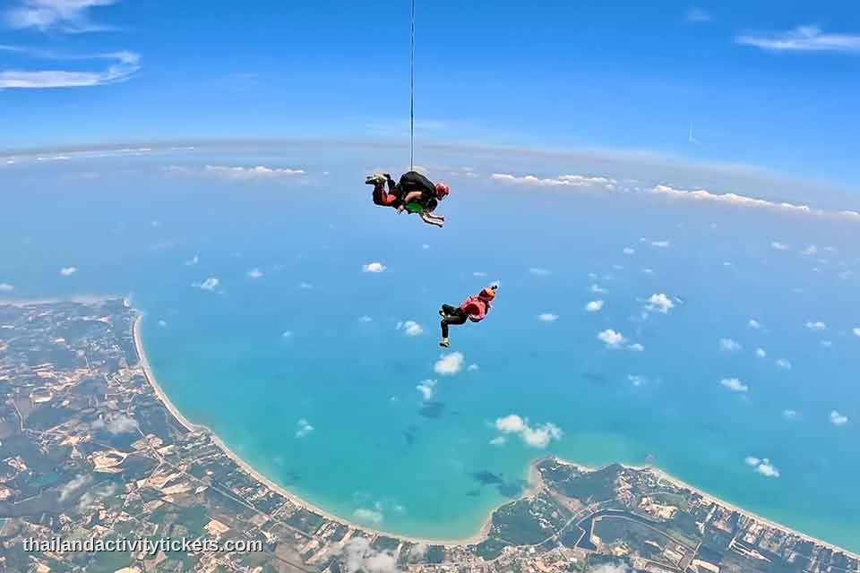First time skydiving Thailand passenger smiling with instructor during freefall