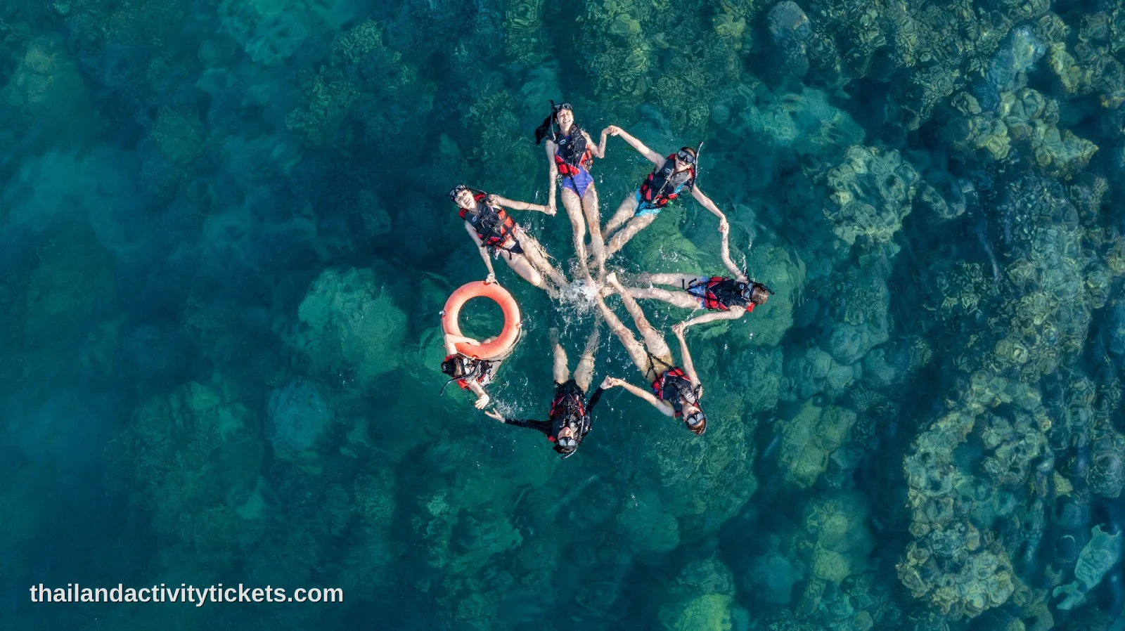 Travelers snorkeling in crystal clear turquoise water at Koh Rin island, Pattaya.