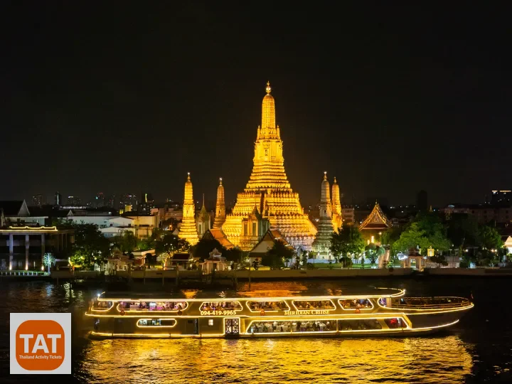 Wat Arun Temple of Dawn illuminated at night along the Chao Phraya River