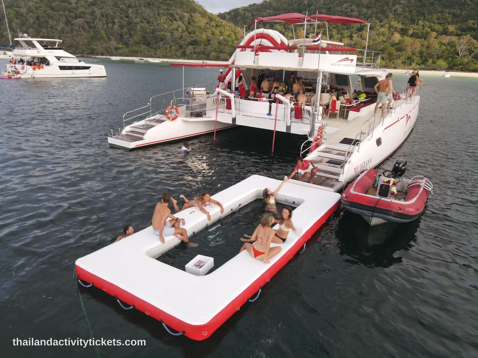 Guests enjoying the yacht water slide and stand-up paddleboarding at Koh Phai.